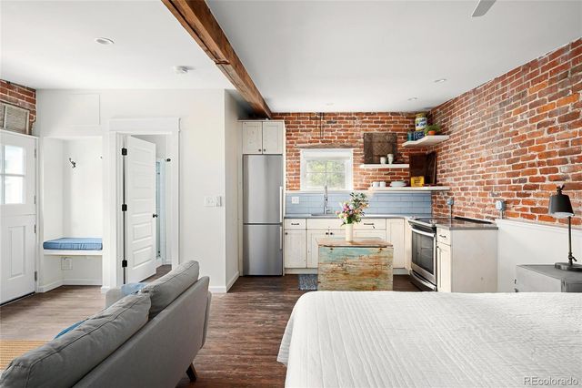 a large bedroom with a bed and wooden floor