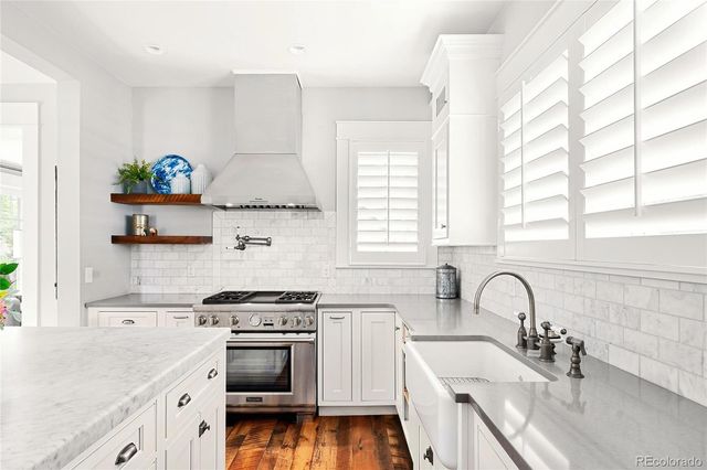 a kitchen with stainless steel appliances a stove a sink a stove and a window