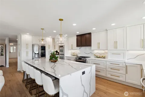 a kitchen with granite countertop white cabinets and refrigerator