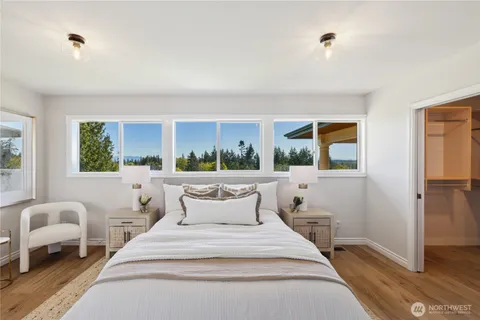 a bedroom with a bed and a large window