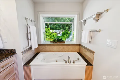 a view of bathroom with bathtub and window