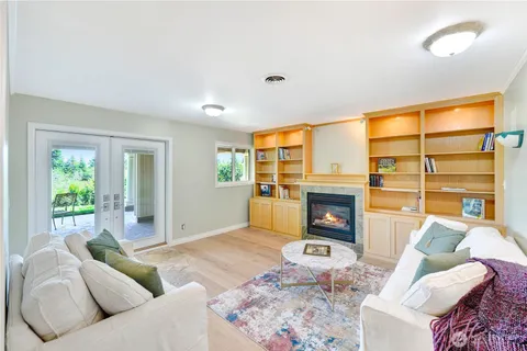 a living room with furniture a fireplace and a floor to ceiling window