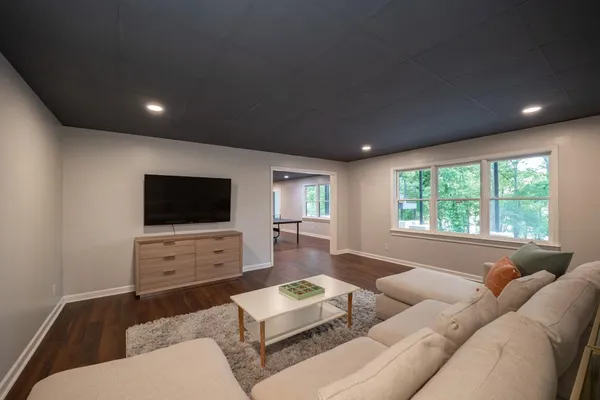 a view of a dining room with furniture a rug and wooden floor