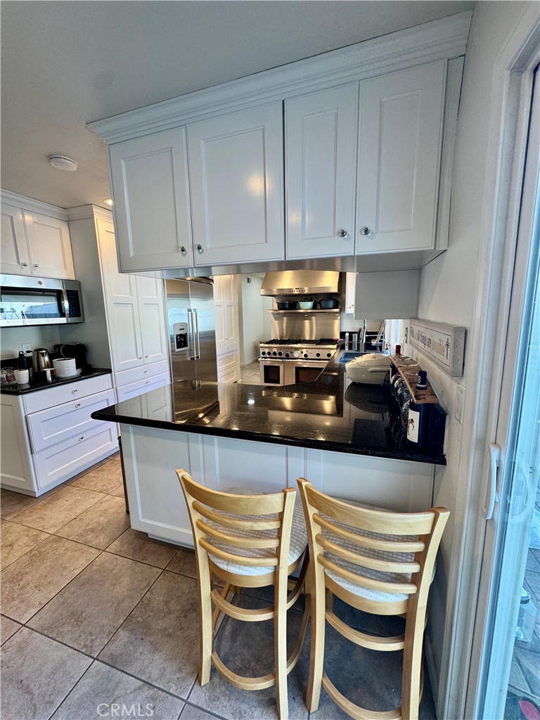 3 White Birch Irvine, CA 92604 - Photo 7 of 22 a kitchen with stainless steel appliances granite countertop a sink a stove a microwave and cabinets
