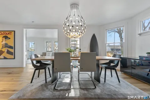 a dining room with furniture a rug and a chandelier