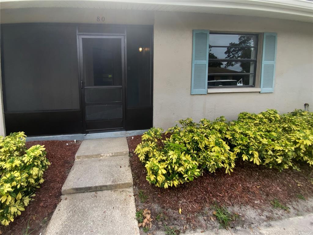 2131 Ridge Road South, Unit 80 Largo, FL 33778 - Photo 1 of 27 a front view of a house with a yard and flowers
