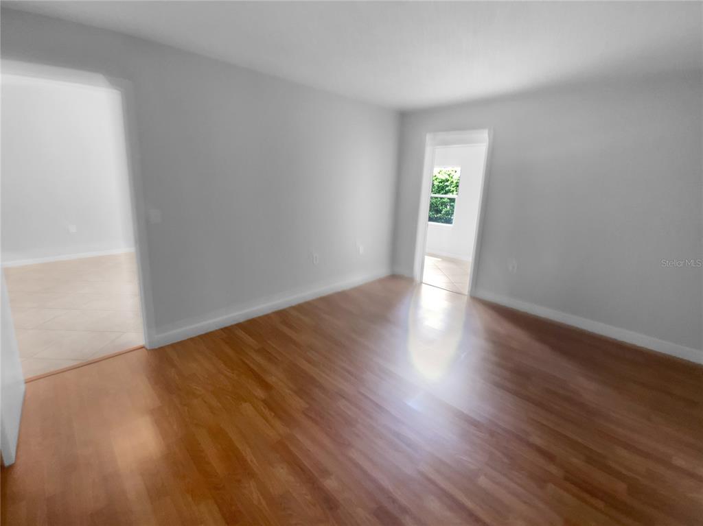 2131 Ridge Road South, Unit 80 Largo, FL 33778 - Photo 17 of 27 a view of an empty room with wooden floor and a window