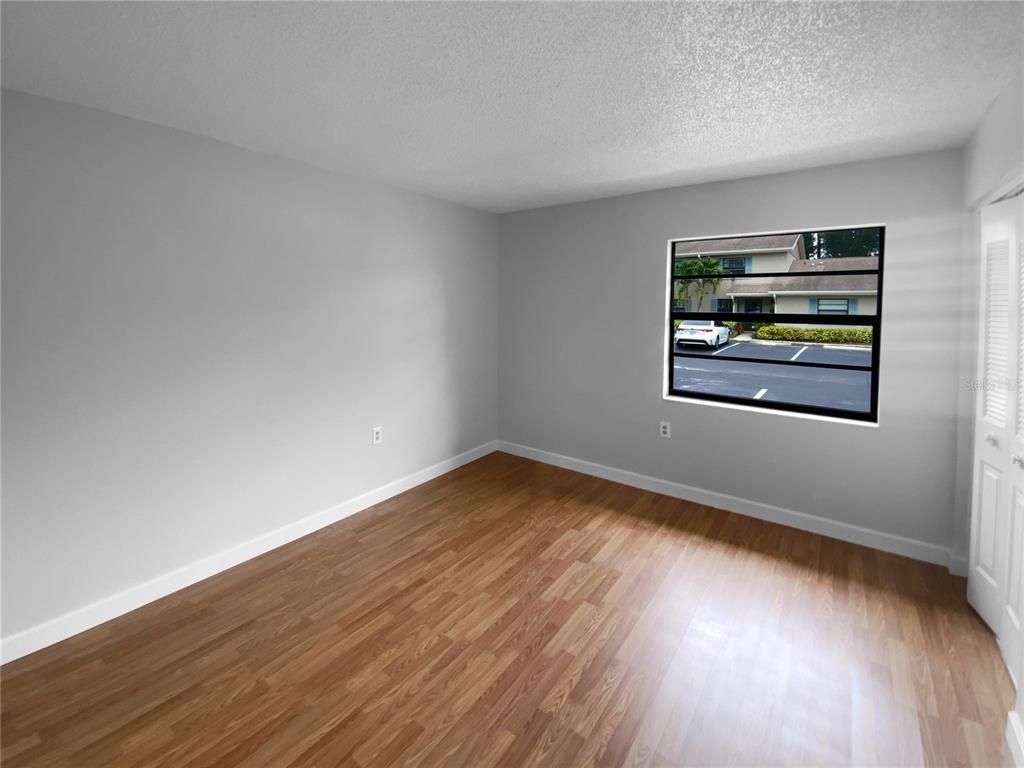 2131 Ridge Road South, Unit 80 Largo, FL 33778 - Photo 5 of 27 a view of an empty room with wooden floor and a window