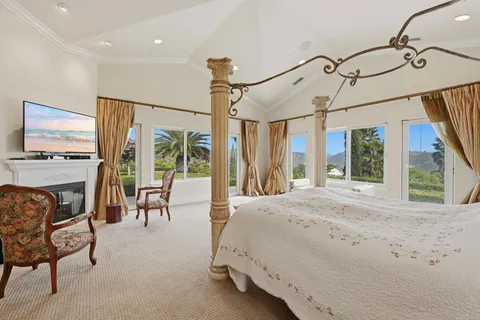 a bedroom with a large bed and a chandelier