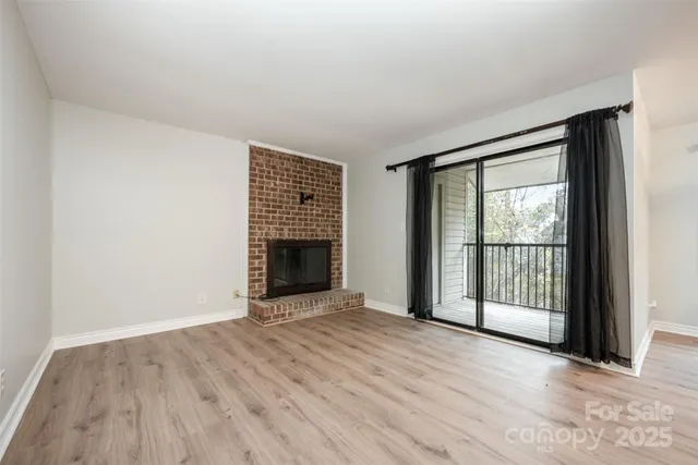 an empty room with wooden floor and fireplace
