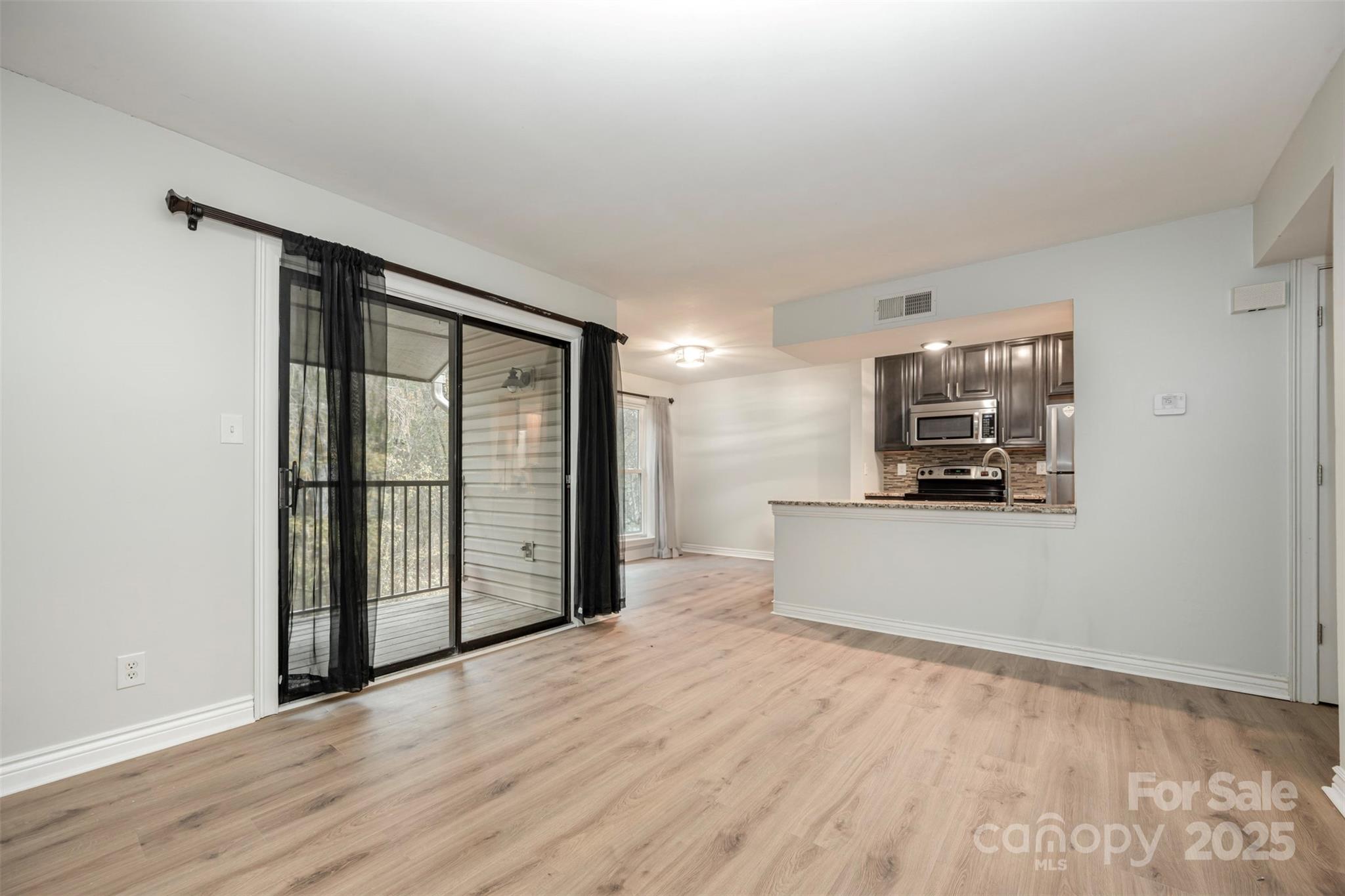 11049 Cedar View Road Charlotte, NC 28226 - Photo 5 of 19 a view of empty room with wooden floor and a window