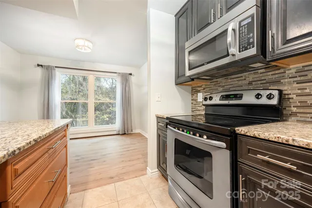 a kitchen with stainless steel appliances granite countertop a stove and a microwave