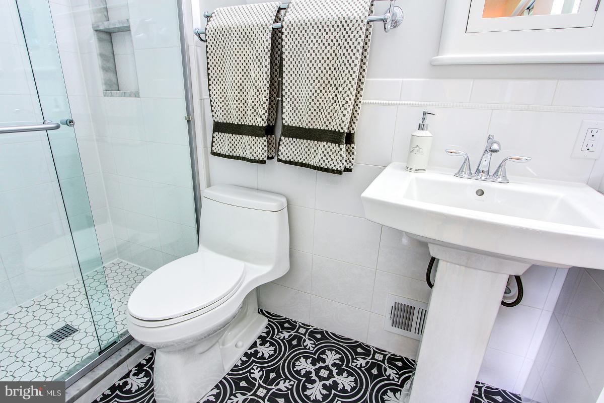 10822 Margate Road Silver Spring, MD 20901 - Photo 18 of 29 a bathroom with a sink toilet and shower