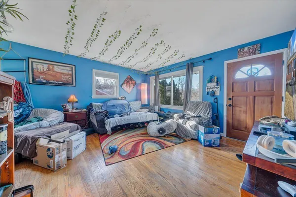 a living room with furniture a wooden floor and next to a window