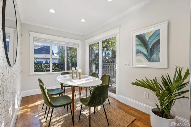a dining room with furniture potted plants and wooden floor