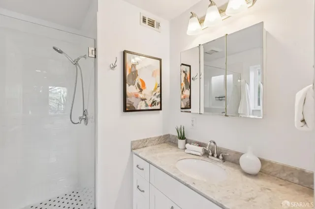a bathroom with a granite countertop sink mirror and double