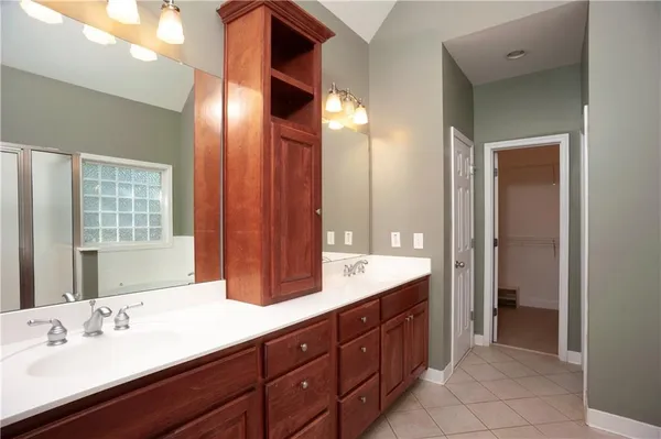 a spacious bathroom with double vanity and a large mirror