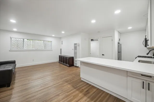 a large white kitchen with wooden floors and white countertops
