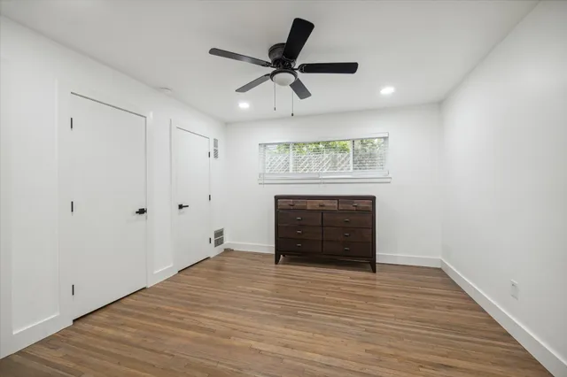 a view of a room with wooden floor and a ceiling fan