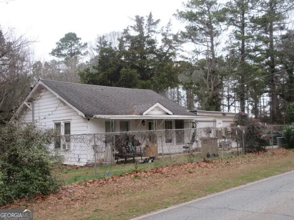 a view of a house with a yard and large trees