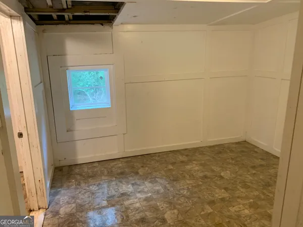 a view of a white house with a tree and wooden fence