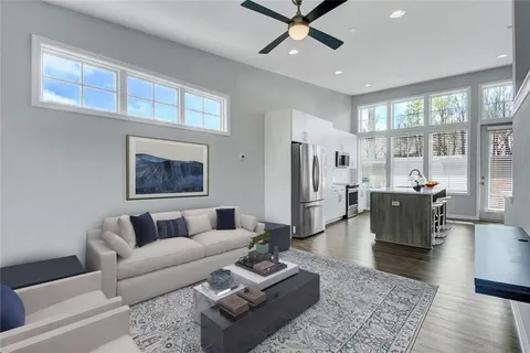 a living room with furniture wooden floor and a large window