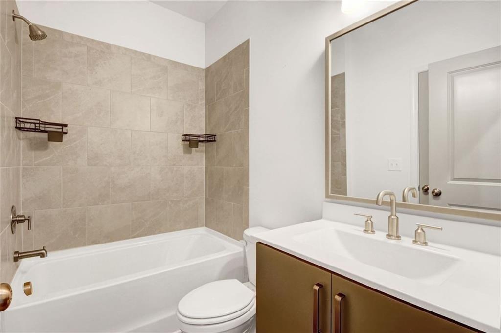 900 Brees Court Atlanta, GA 30318 - Photo 20 of 33 a bathroom with a granite countertop bathtub shower sink vanity mirror and toilet