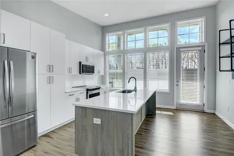 a kitchen with stainless steel appliances granite countertop a refrigerator a sink and a stove