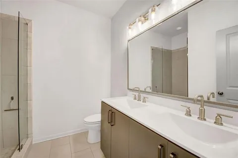 a bathroom with a double vanity sink toilet and a mirror