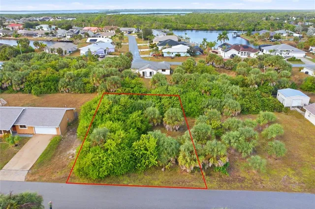 an aerial view of residential houses with outdoor space and trees