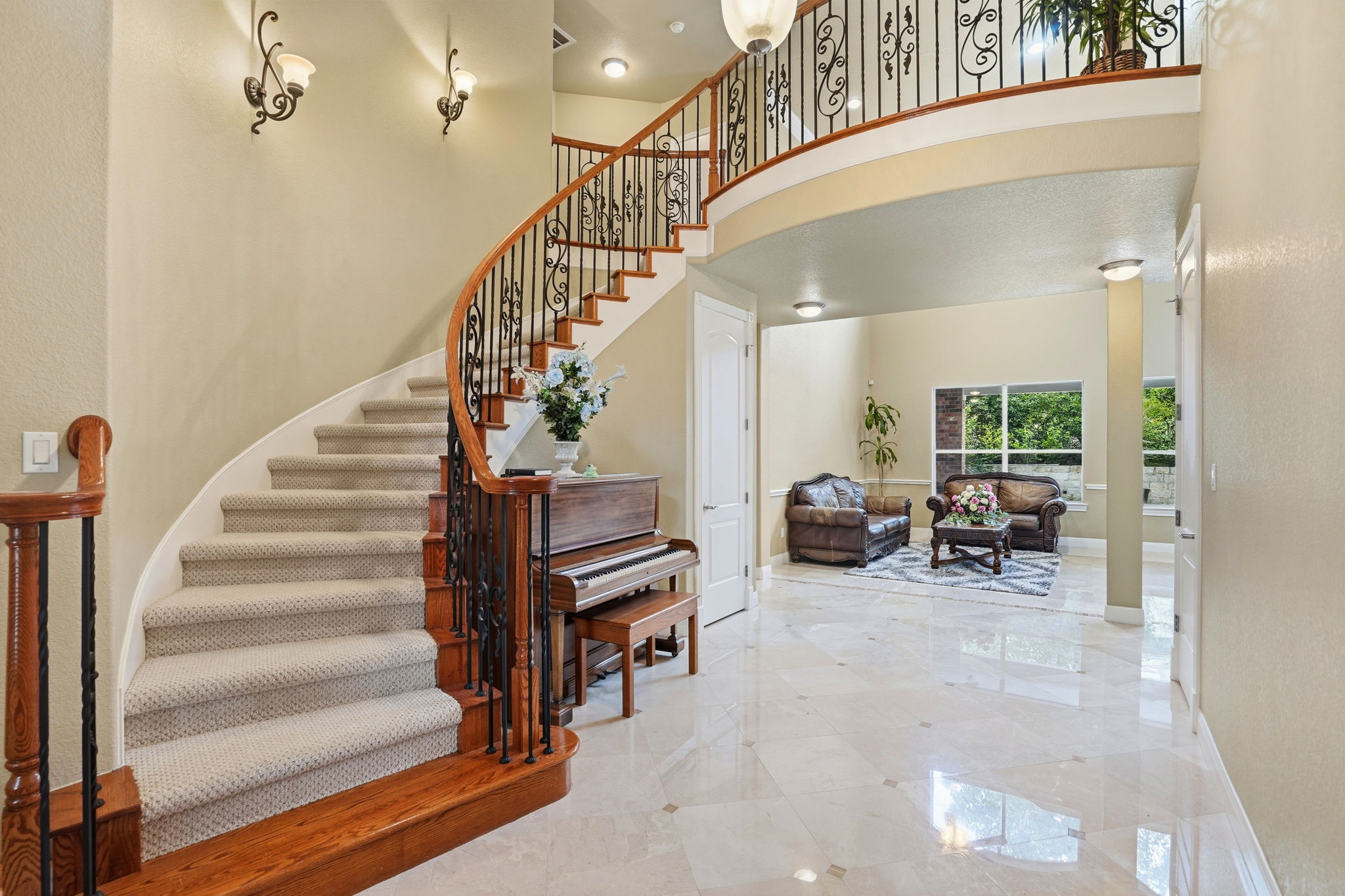222 Vailco Lane Austin, TX 78738 - Photo 4 of 39 Grand entryway featuring a curved staircase with wrought iron balusters and wood-finish handrails