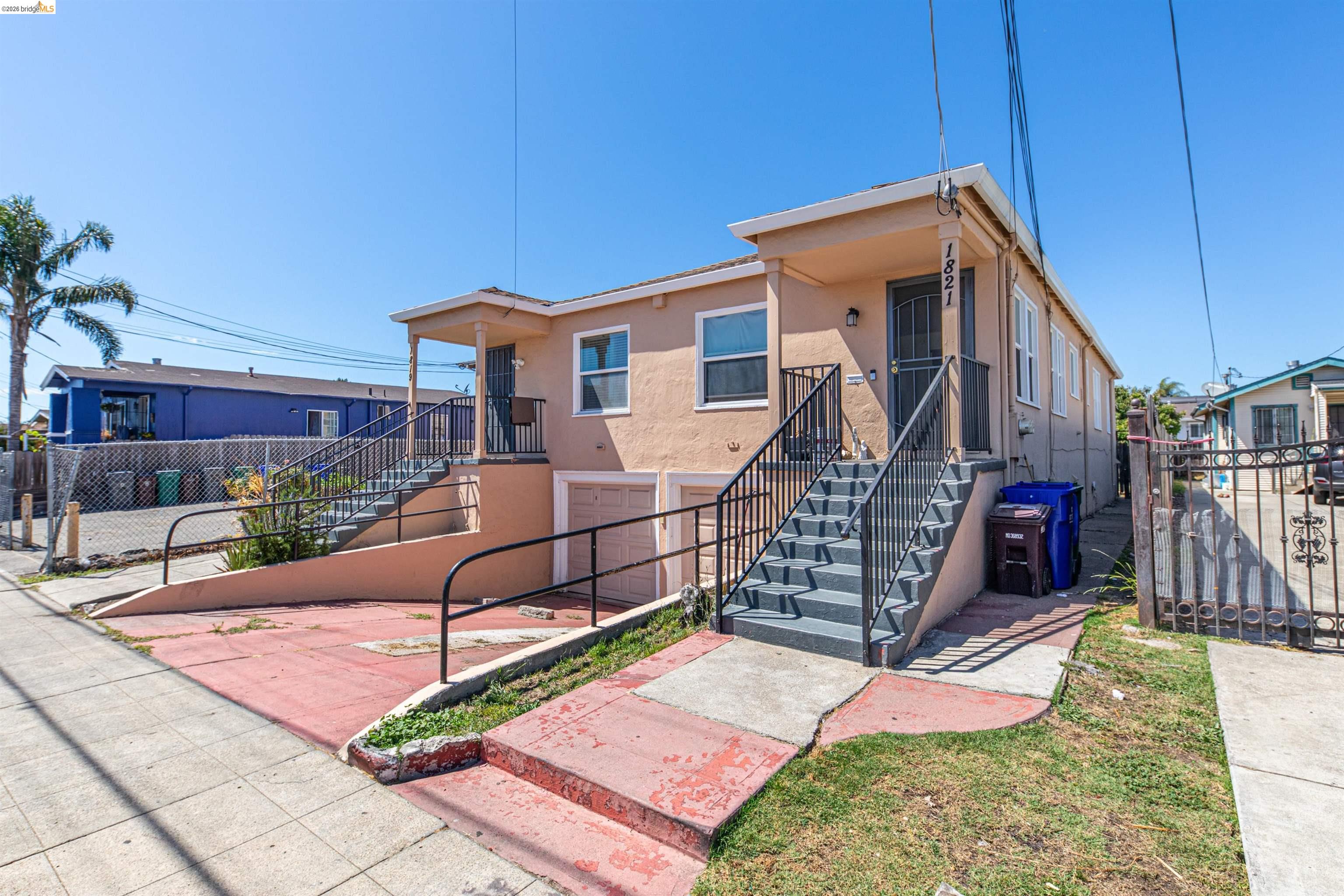 1821 74th Avenue Oakland, CA 94621 - Photo 15 of 27 View of front of house featuring stairway and stucco siding