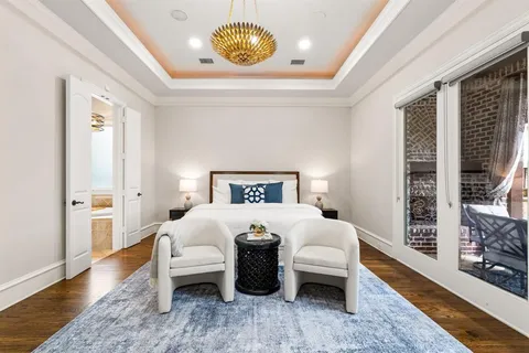 a bedroom with a large bed and a chandelier