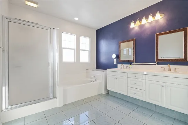 a spacious bathroom with a double vanity sink a mirror and a bathtub