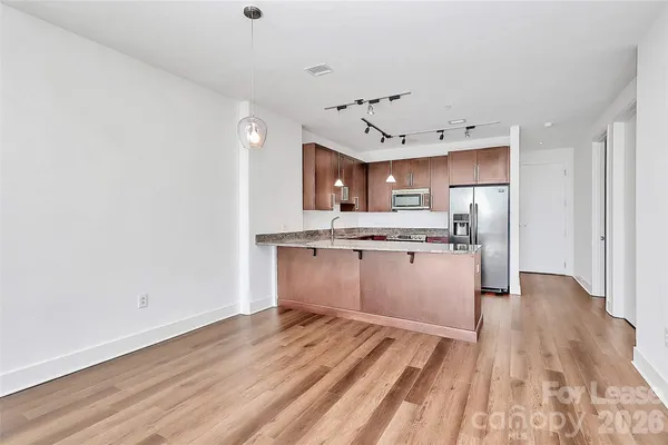 a view of kitchen with granite countertop cabinets and refrigerator