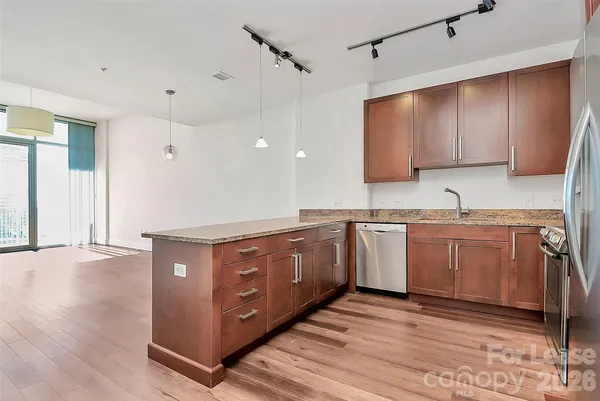 a kitchen with granite countertop a sink cabinets and wooden floor