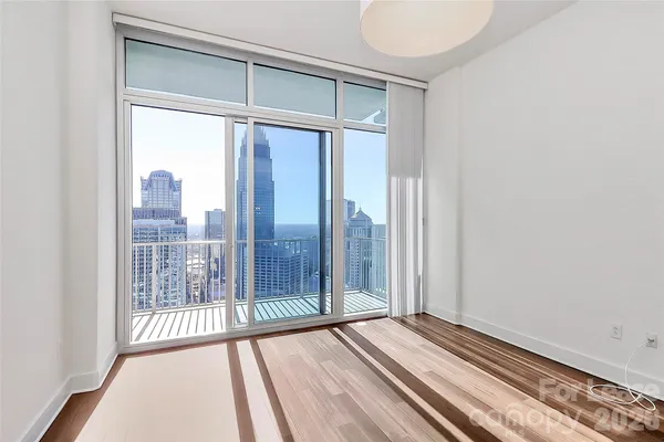 a view of a room with wooden floor and windows