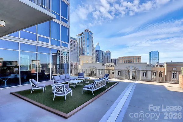 a living room with furniture and a dining table with rug