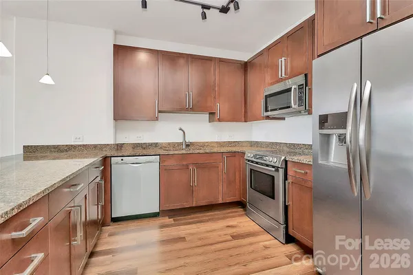 a kitchen with stainless steel appliances granite countertop a stove a sink and a refrigerator