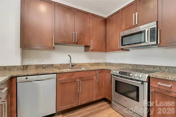 a kitchen with granite countertop cabinets stainless steel appliances and a sink