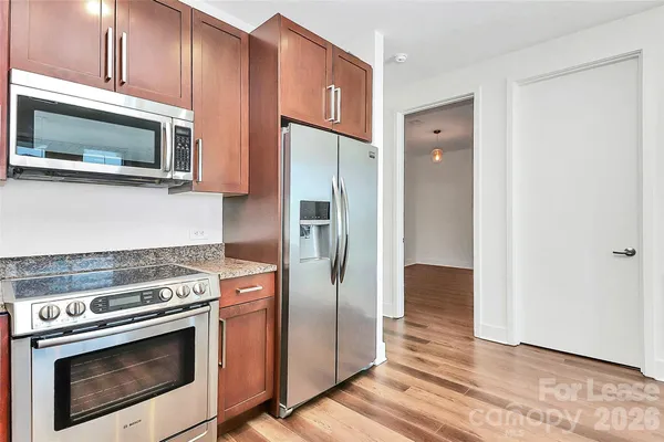 a kitchen with stainless steel appliances wooden cabinets and a stove top oven