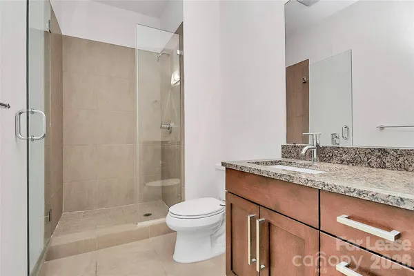 a bathroom with a granite countertop sink toilet and shower