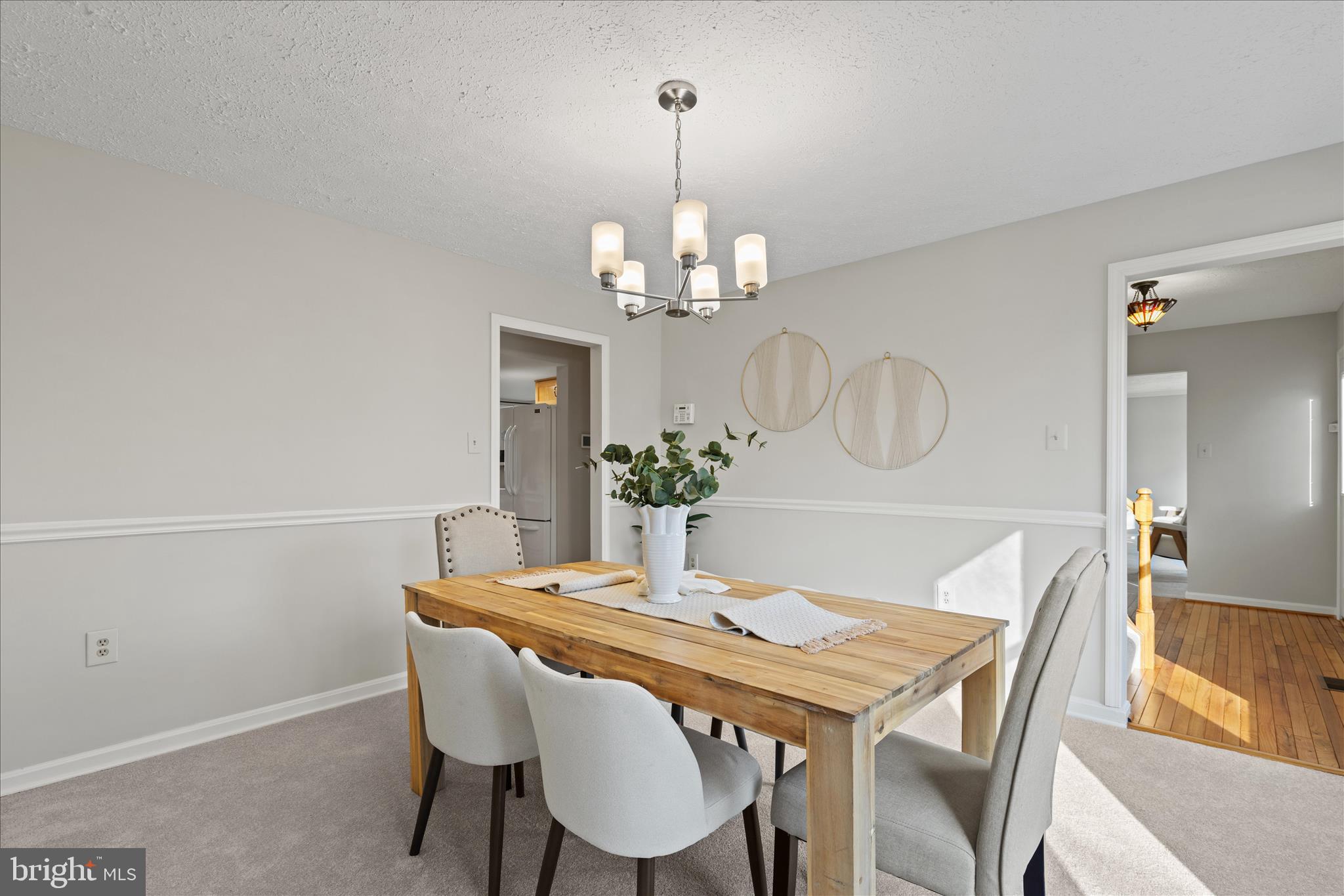 865 Moffett Forge Road Herndon, VA 20170 - Photo 12 of 62 a dining room with wooden floor a chandelier a wooden table and chairs