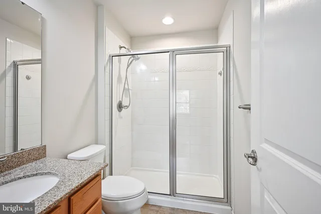 a bathroom with a granite countertop sink toilet and shower