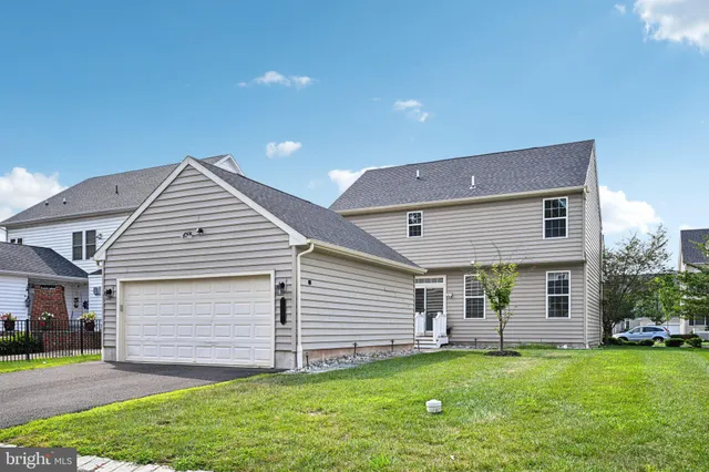 a view of a house with a yard and a large tree