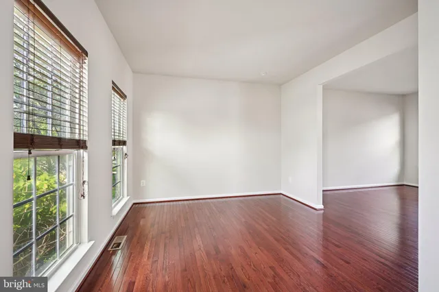 a view of a big room with wooden floor and windows