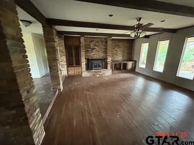 a view of an empty room with a fireplace and a window