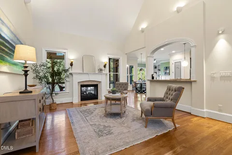 a large kitchen with stainless steel appliances kitchen island granite countertop a refrigerator a stove a sink and a dining table with wooden floor