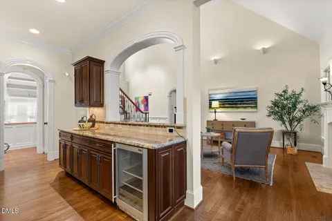 a kitchen with stainless steel appliances granite countertop a stove oven a dining table and chairs with wooden floor