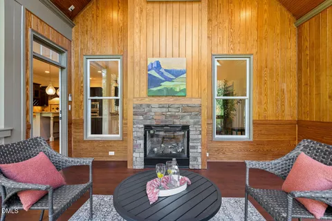 a view of an empty room with wooden floor and a chandelier